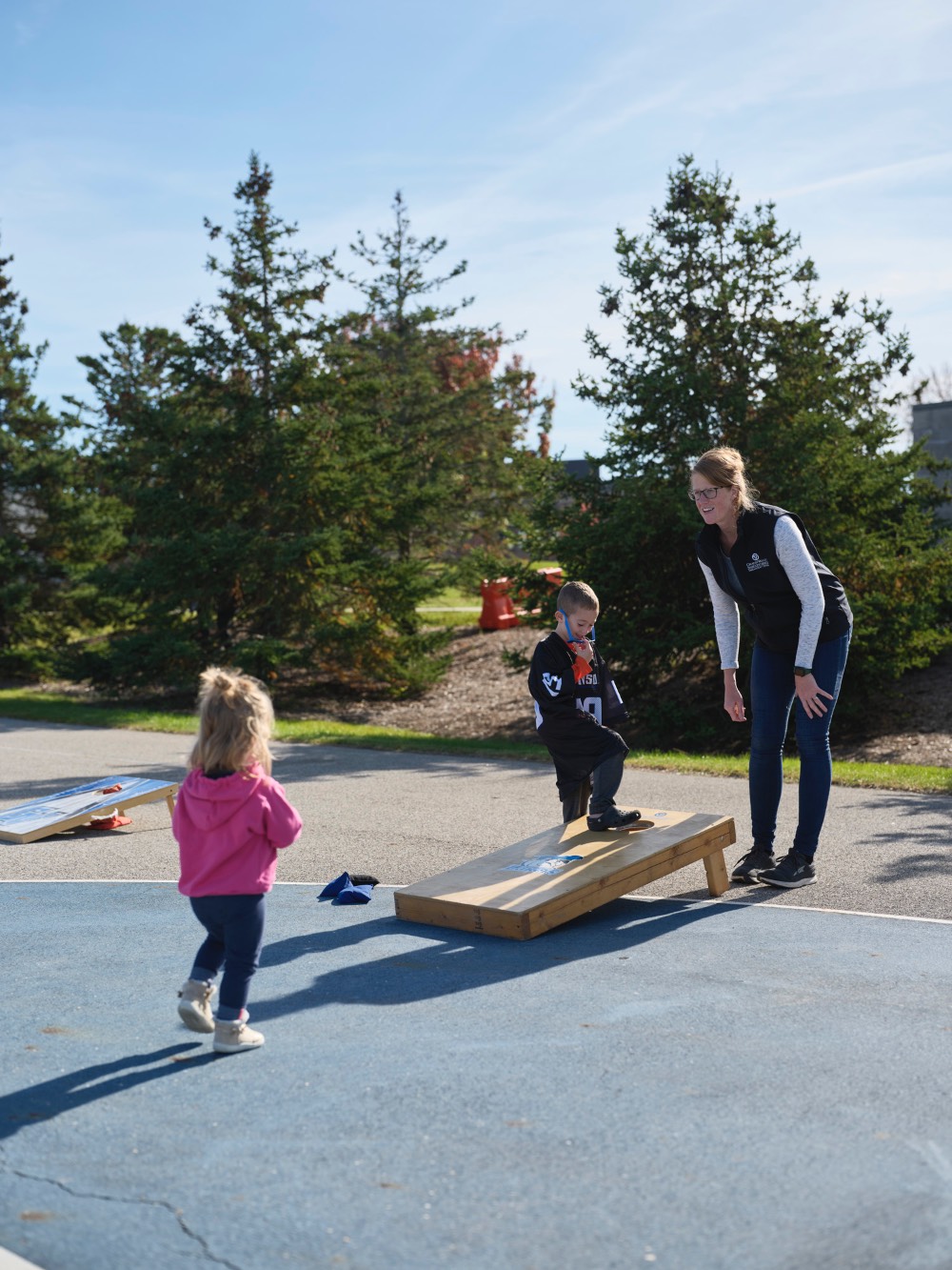 Mom and her son and daughter playing corn hole